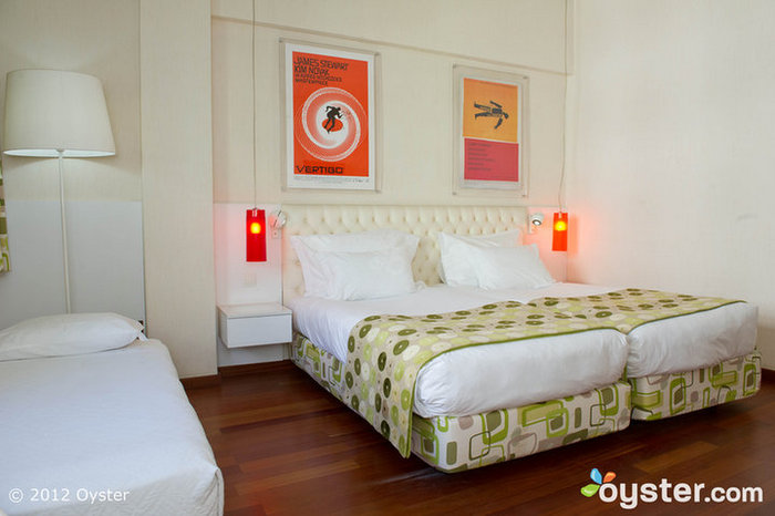 El área para dormir de la habitación familiar cuenta con toques de decoración funky, como el esquema de color rosa y naranja.
