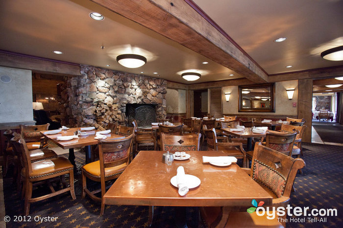 Le restaurant Glitretind propose une ambiance chaleureuse avec des plafonds à poutres apparentes, des cheminées en pierre et des chaises en cuir confortables.