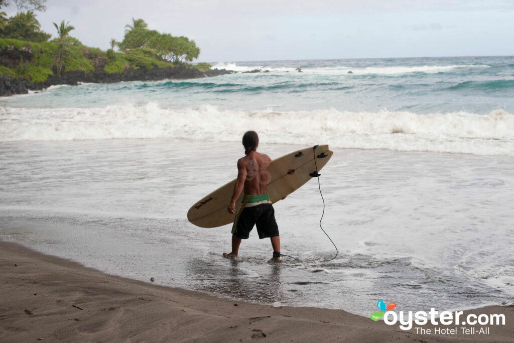 Ein einsamer Surfer bei Hamoa Beach bei der Travaasa Hana, Maui .