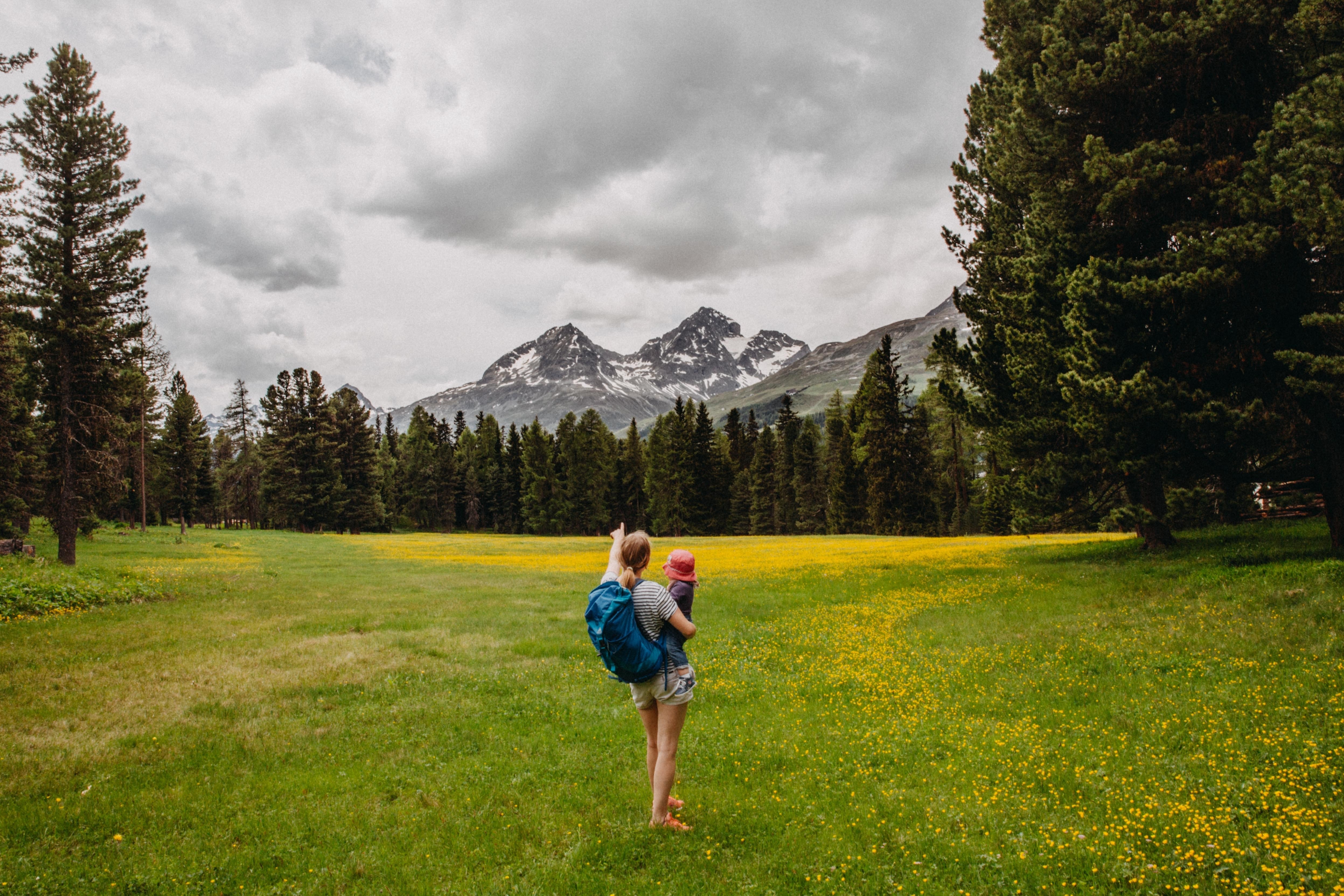 Mother Holding Child Hiking in the Mountains