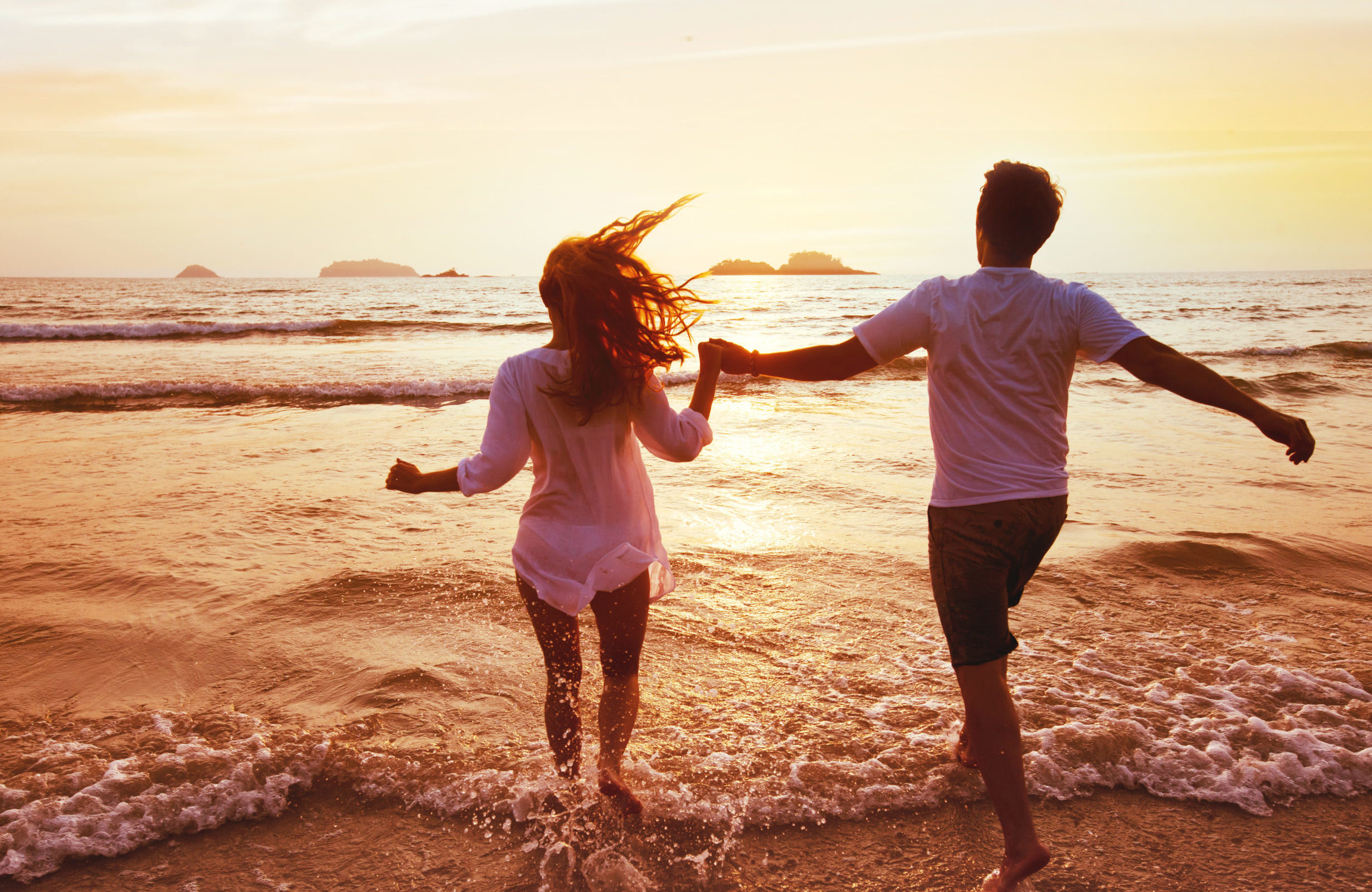 Couple running into the ocean