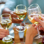 Hands toasting with wine glasses