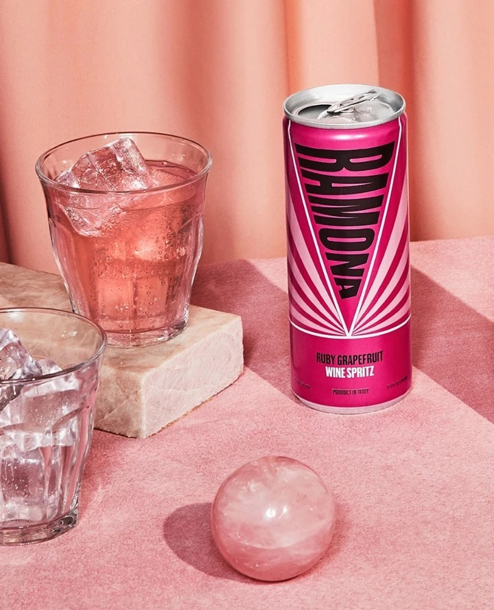 Can of Romona Ruby Grapefruit Wine Spritz and a full tumbler glass on a pink table